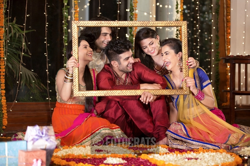 group of friends posing in wooden frame on diwali festival