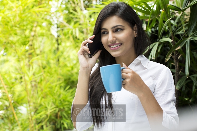 attractive female talking on the phone while having coffee
