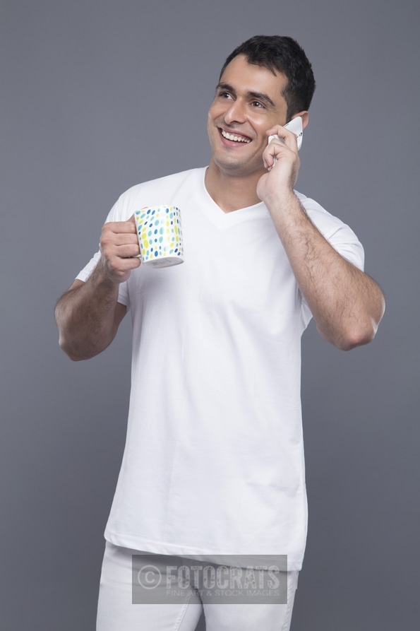 man with coffee mug talking on phone