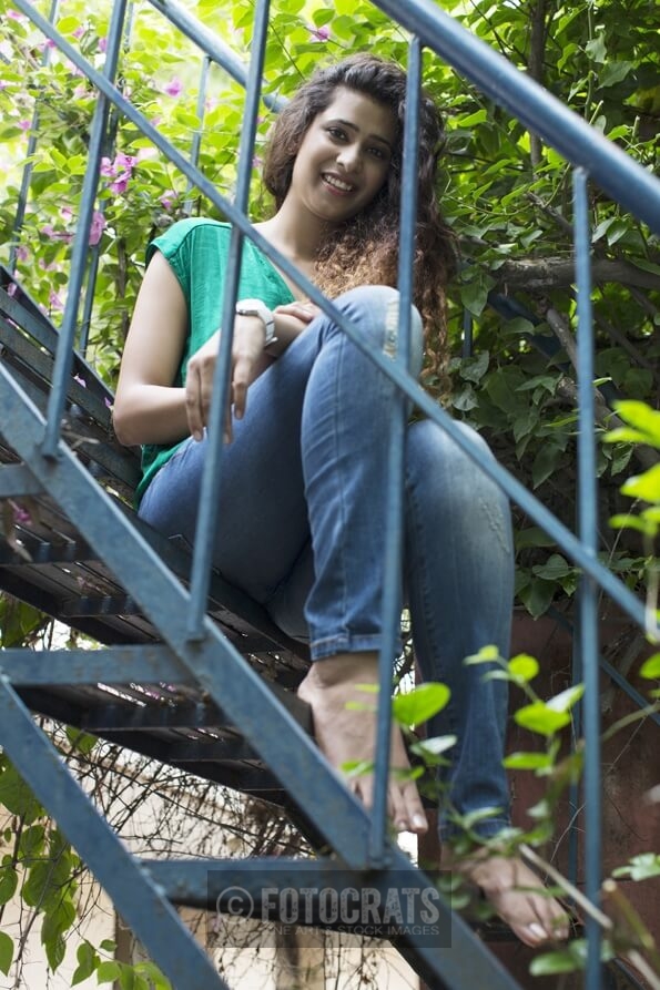 portrait of a pretty girl sitting alone in the garden stairs