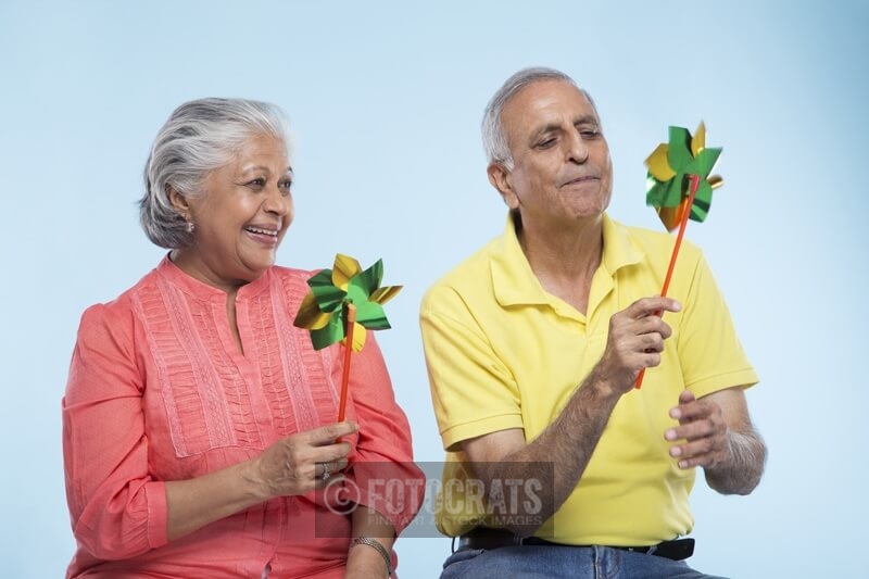 old couple playing with windmill toy 