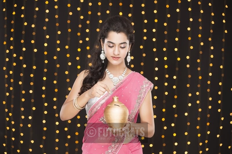 woman in ethnic wear posing with piggy bank