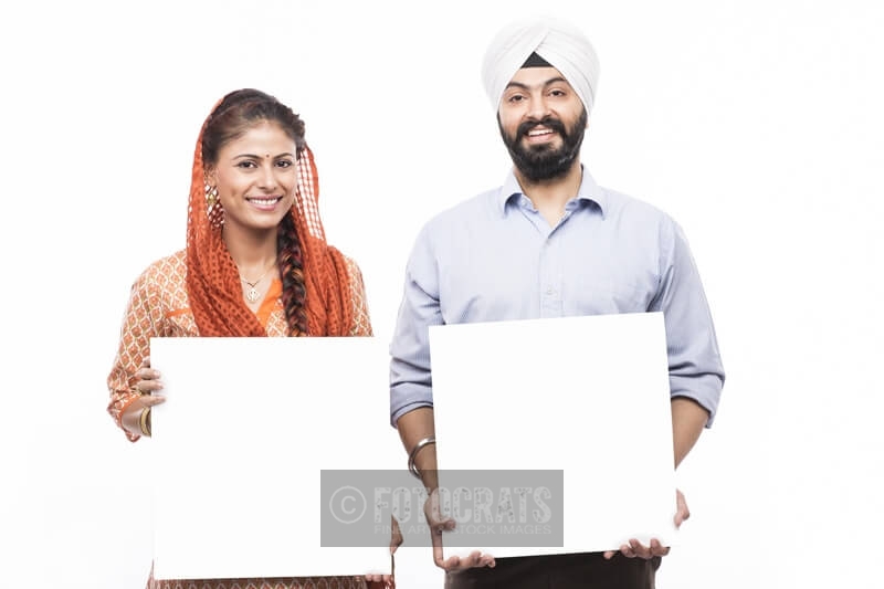 sikh couple standing with a message board 