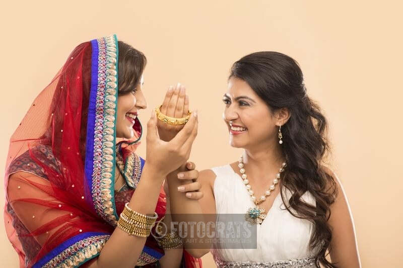 woman giving bangle to another woman