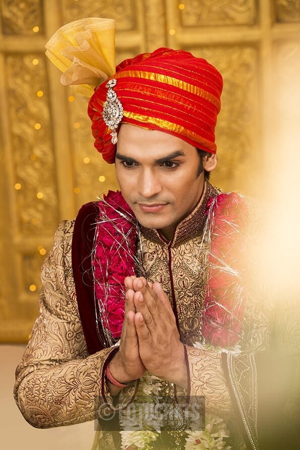 indian groom sitting with hands folded 