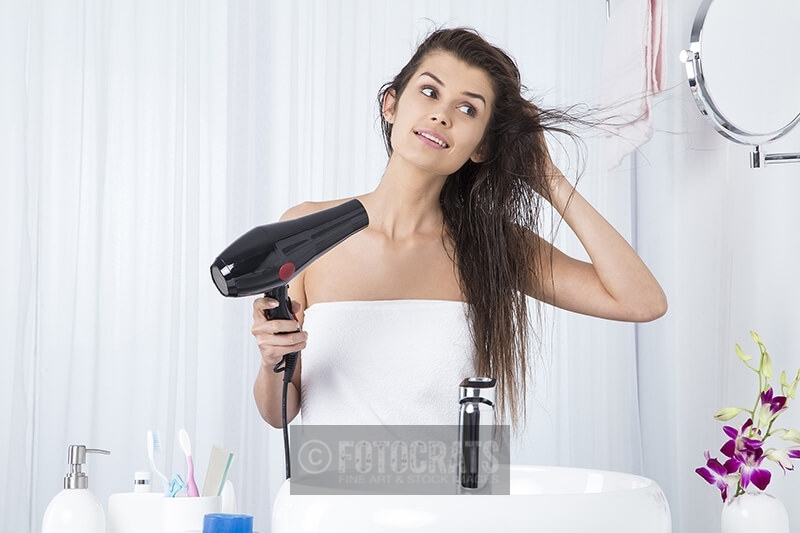 woman using dryer after shower