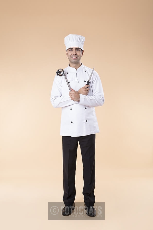 chef posing with knife and ladle