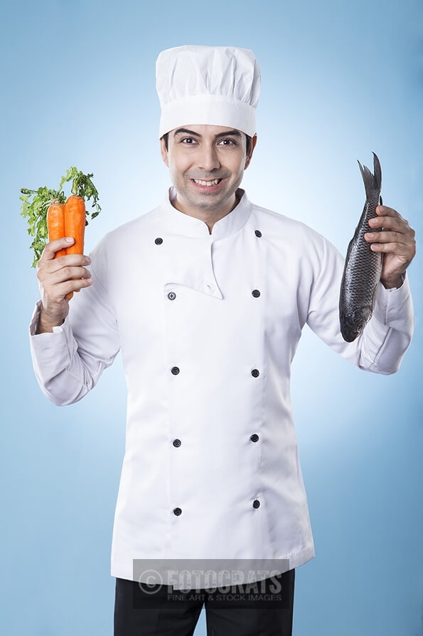 chef posing with fish and carrots