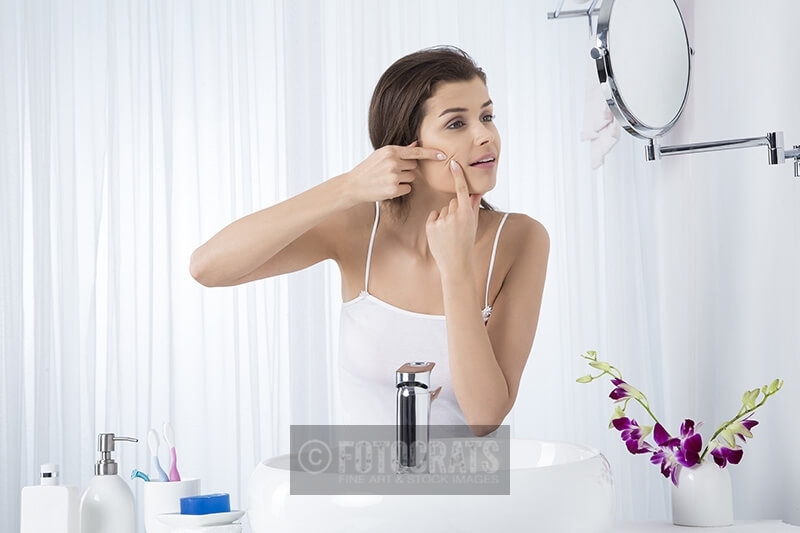 woman squeezing pimple 