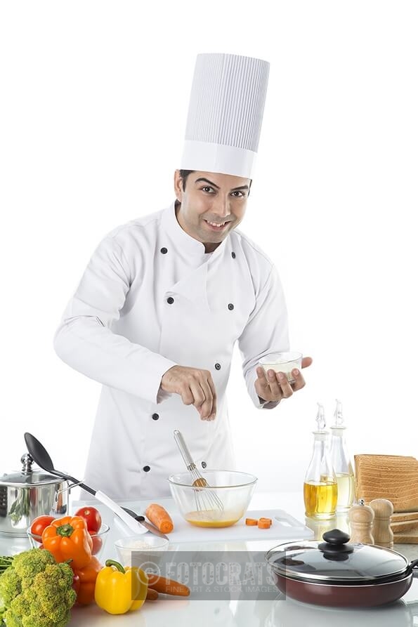 chef adding salt to the bowl 