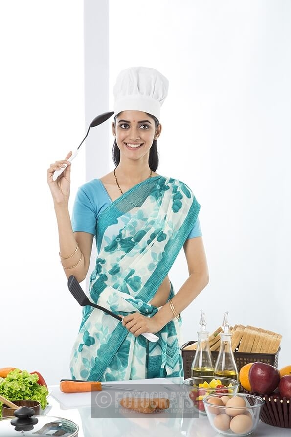 Indian housewife posing with spatula and ladle