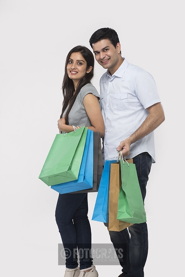 Couple posing with shopping bags while looking at camera
