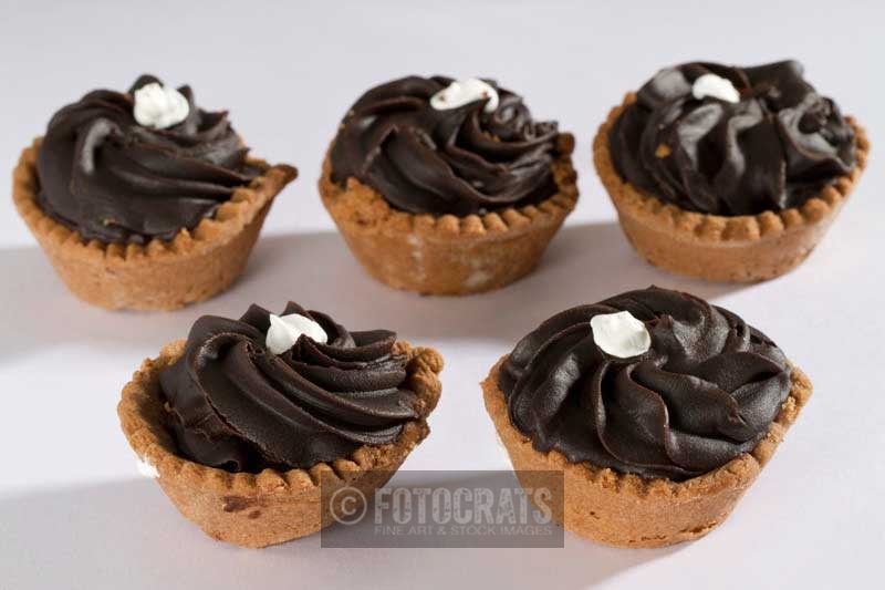 five cupcakes against white background