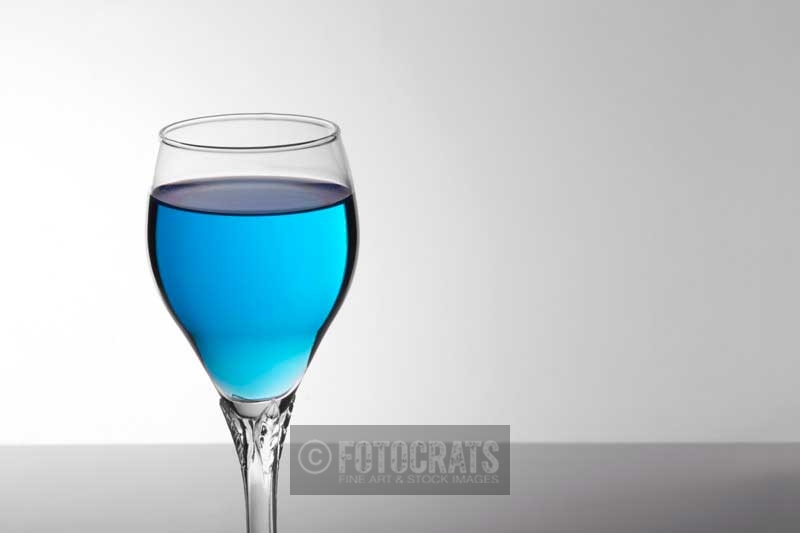 a glass of blue mocktail against white background 