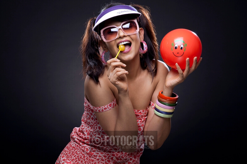 trendy model posing with red ball and lollipop