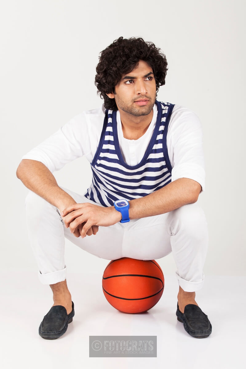 college boy sitting on basketball