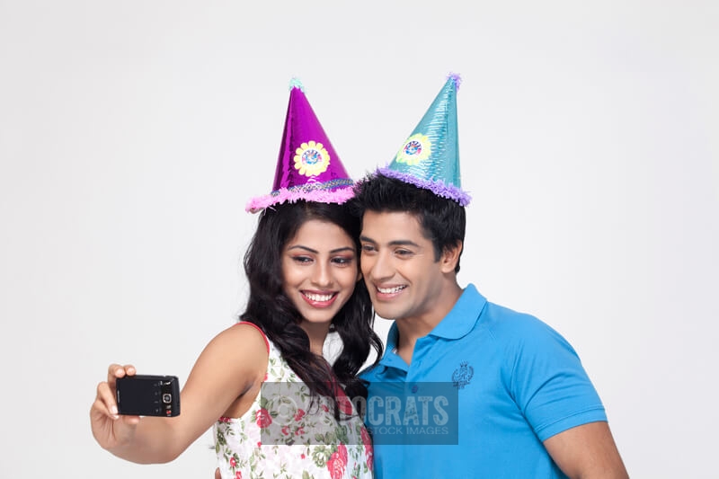 couple smiling while taking their picture from mobile camera 