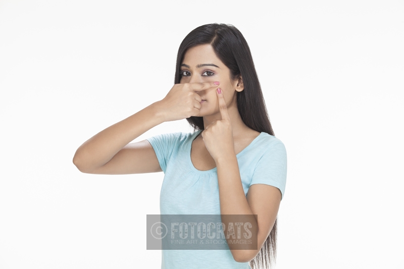 a girl squeezing a pimple on her cheek