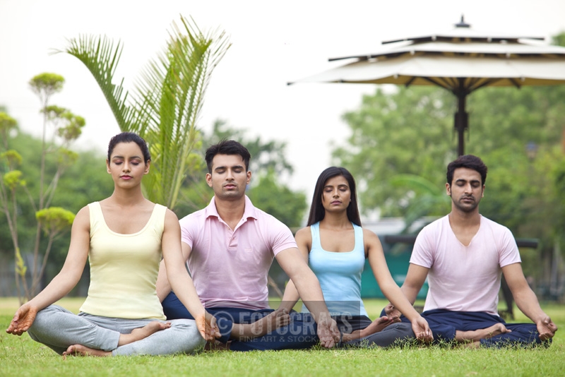 people doing yoga in park