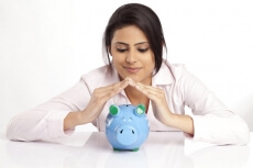 woman in a pink shirt with a blue piggy bank