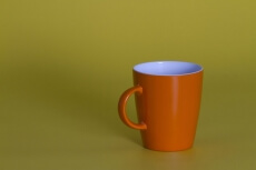 orange coffee cup against yellow background
