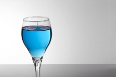 glass of blue mocktail on white background