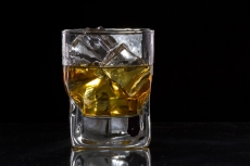 a glass of scotch with ice cubes