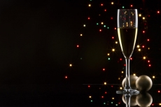 champagne glass with black background with decorative balls