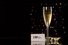 a picture of a glass of champagne with love note on dark background
