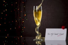 champagne glass with black background and note