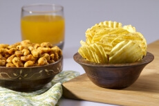 chips and peanuts with a glass of juice