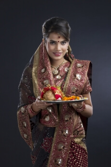 beautiful woman in a saree holding pooja thali