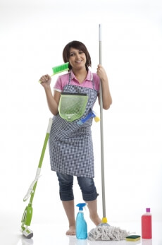 housewife wearing cleaning uniform smiling against white background