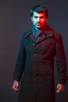 man posing in overcoat while looking at the camera 