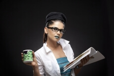 girl wearing green lipstick posing with magazine and coffee cup