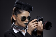 woman in corporate look wearing aviators with a dslr camera