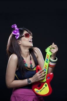 teenage girl with a side pose holding a toy guitar