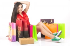 girl sitting on floor with shopping bags around 