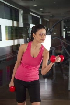 girl posing with red dumbbells 