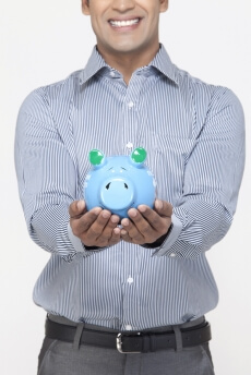 smiling man with piggy bank against white background