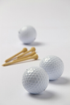 three golf balls with golf tees