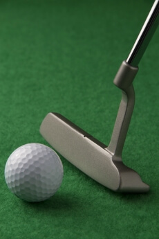 golf club and golf ball on a green background
