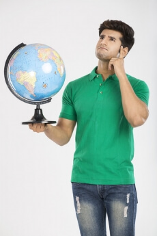 man thinking while holding a desktop globe