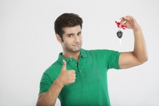man showing thumbs up while holding a car key 
