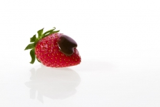 only strawberry against white background with chocolate syrup drop in 