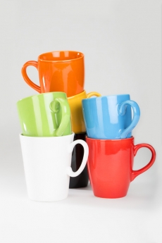 set of colourful cups lying against white background 