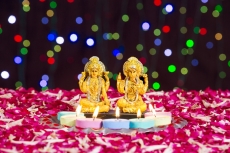 lord ganesha and luxmi statues with diyas in front