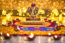 beautiful idol of ganesh placed against bright lights on diwali