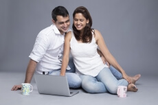 couple looking at the laptop while having coffee