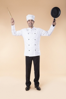 chef posing with rolling pin and frying pan